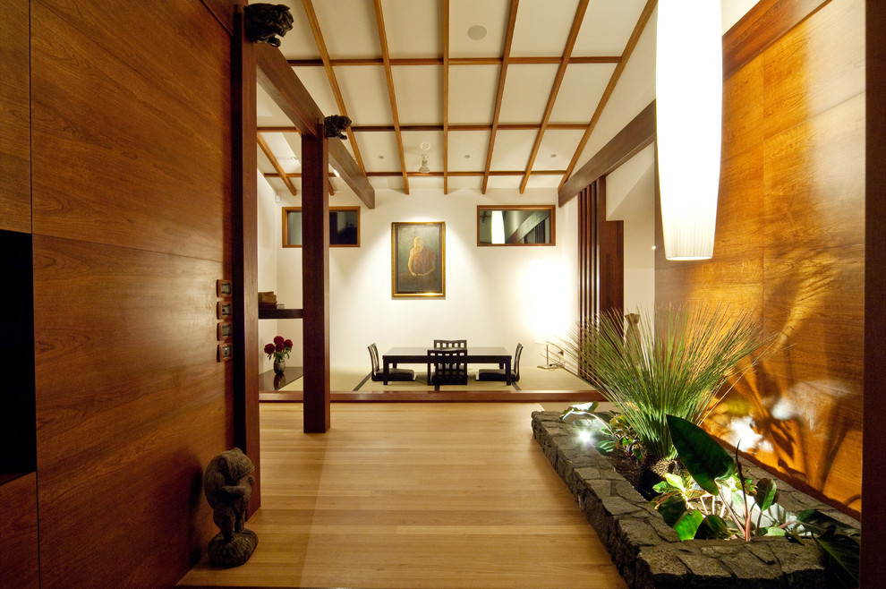 Imagen de comedor asiático abierto con paredes blancas, suelo de madera clara y suelo beige