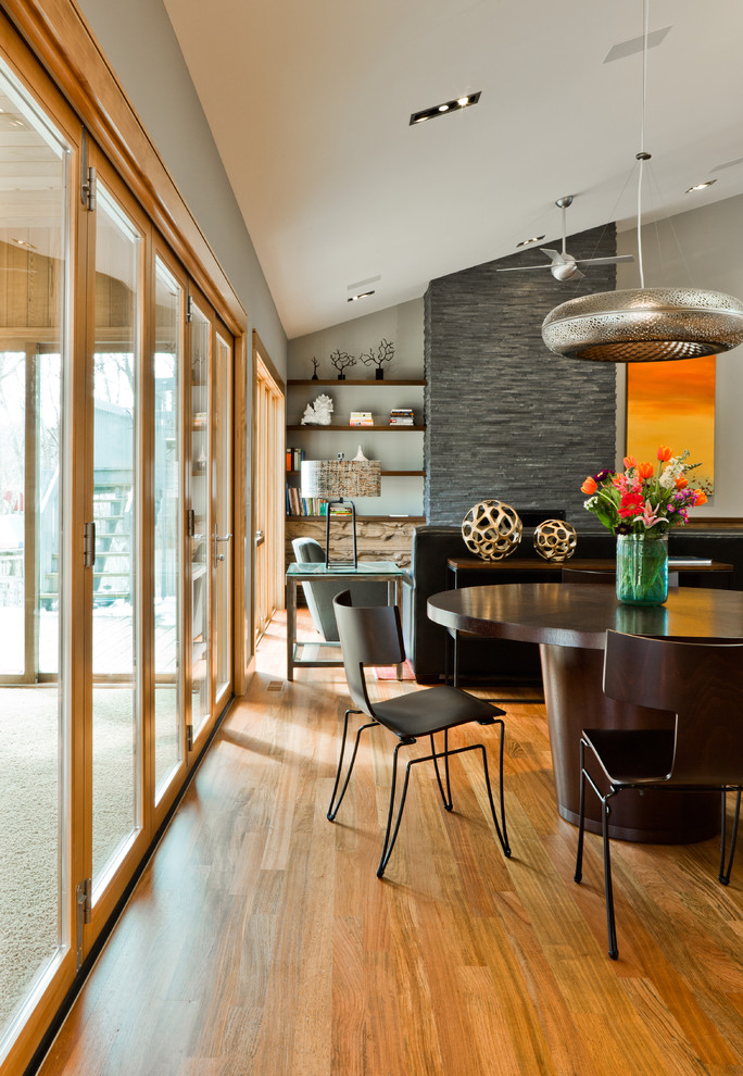 Inspiration for a contemporary open plan dining room in Minneapolis with feature lighting.
