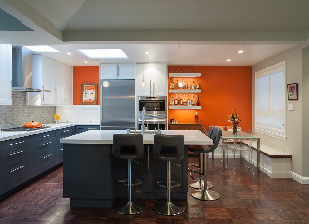 Cette photo montre une petite salle à manger ouverte sur la cuisine moderne avec un mur orange et parquet foncé.