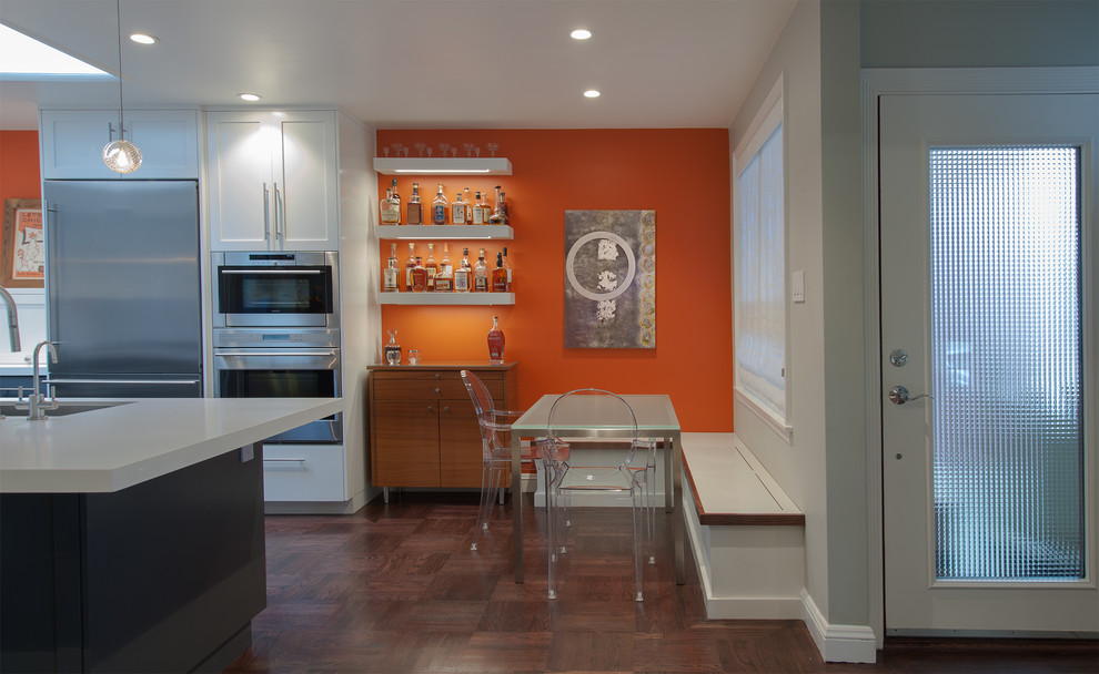 Inspiration för små retro matplatser med öppen planlösning, med orange väggar och mörkt trägolv