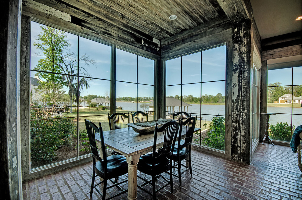 Inspiration for a coastal dining room in Jackson with brick flooring.