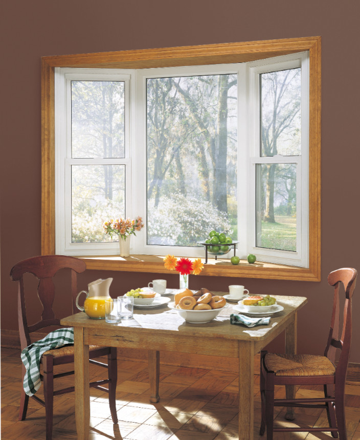 Aménagement d'une petite salle à manger ouverte sur la cuisine montagne avec un mur marron et un sol en bois brun.