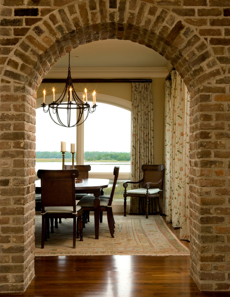 Idée de décoration pour une salle à manger ouverte sur la cuisine tradition de taille moyenne avec un mur jaune et un sol en bois brun.