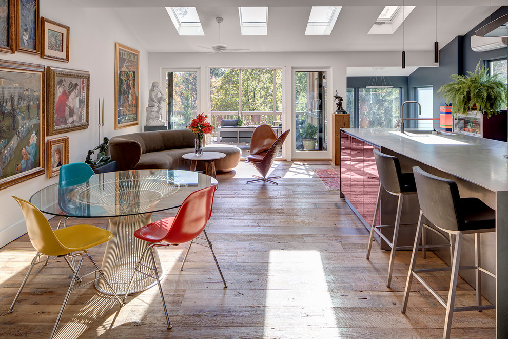 Ispirazione per una sala da pranzo aperta verso il soggiorno eclettica con pareti bianche, pavimento in legno massello medio e pavimento marrone