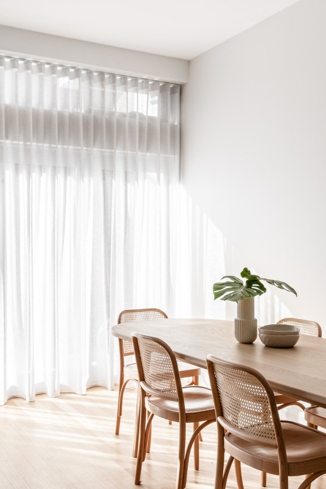 Ispirazione per una sala da pranzo aperta verso il soggiorno minimal di medie dimensioni con pareti bianche e parquet chiaro
