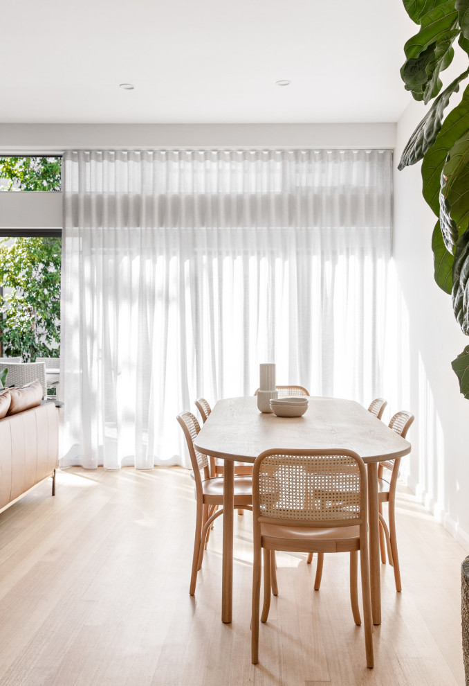 Foto di una sala da pranzo aperta verso il soggiorno contemporanea di medie dimensioni con pareti bianche, parquet chiaro e pavimento beige