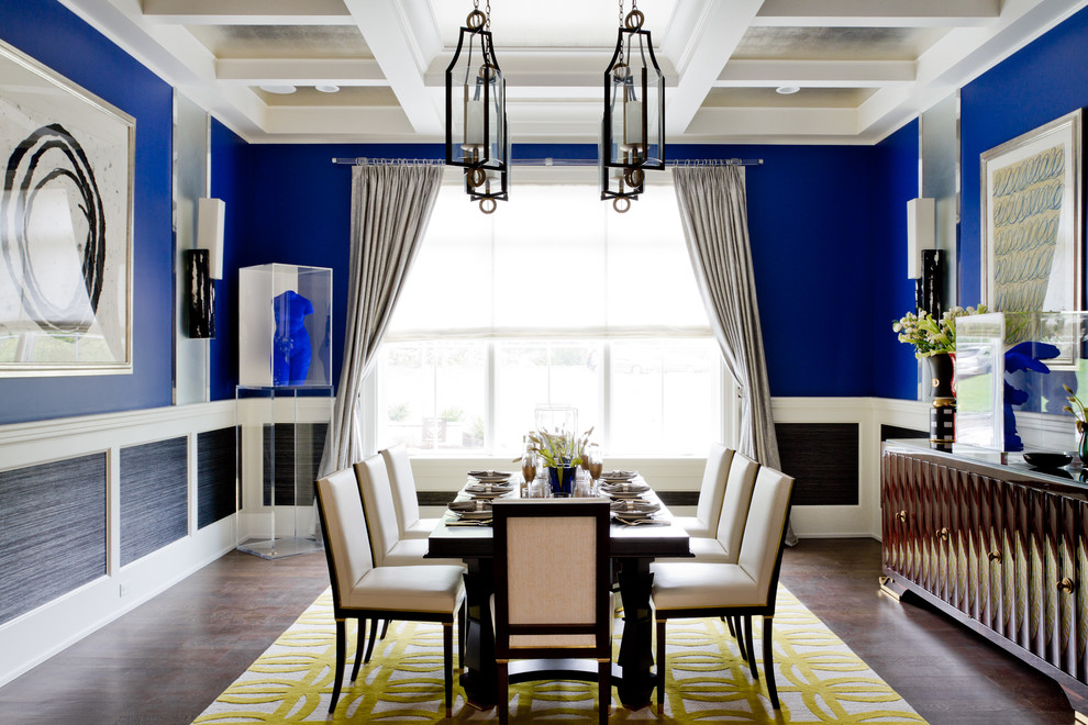 Cette photo montre une salle à manger tendance fermée avec un mur bleu et parquet foncé.