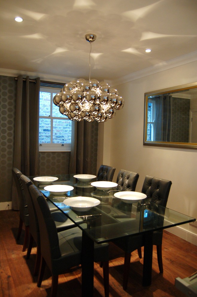 Cette photo montre une salle à manger ouverte sur la cuisine tendance de taille moyenne avec un sol en bois brun et un mur beige.