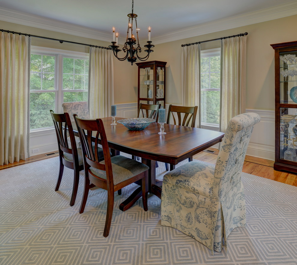 Large elegant medium tone wood floor and brown floor enclosed dining room photo in New York with beige walls and no fireplace
