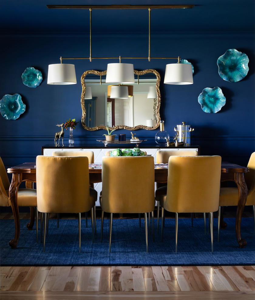 Modelo de comedor abierto con paredes azules y suelo de madera en tonos medios