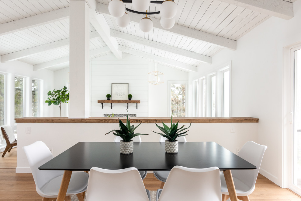 Idée de décoration pour une salle à manger ouverte sur le salon design avec un mur blanc, un sol en bois brun et un sol marron.