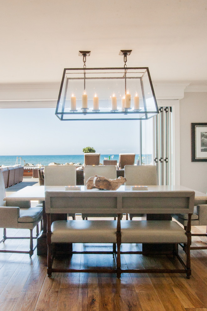 Esempio di una sala da pranzo aperta verso il soggiorno costiera con pareti bianche e pavimento in legno massello medio