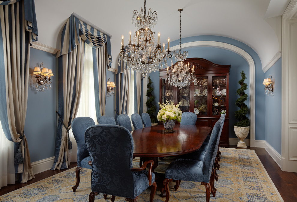 На фото: огромная отдельная столовая в классическом стиле с синими стенами и темным паркетным полом с