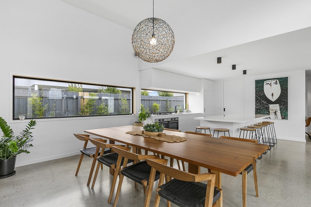 Offenes, Mittelgroßes Modernes Esszimmer mit weißer Wandfarbe und Betonboden in Geelong