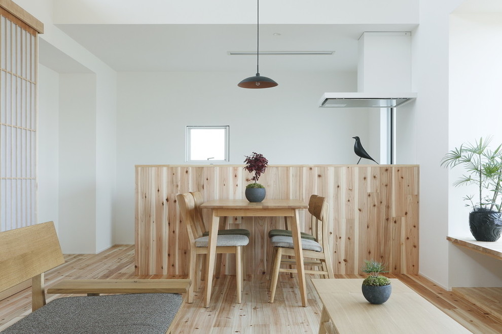 Foto di una piccola sala da pranzo aperta verso il soggiorno etnica con pareti bianche, parquet chiaro e pavimento beige