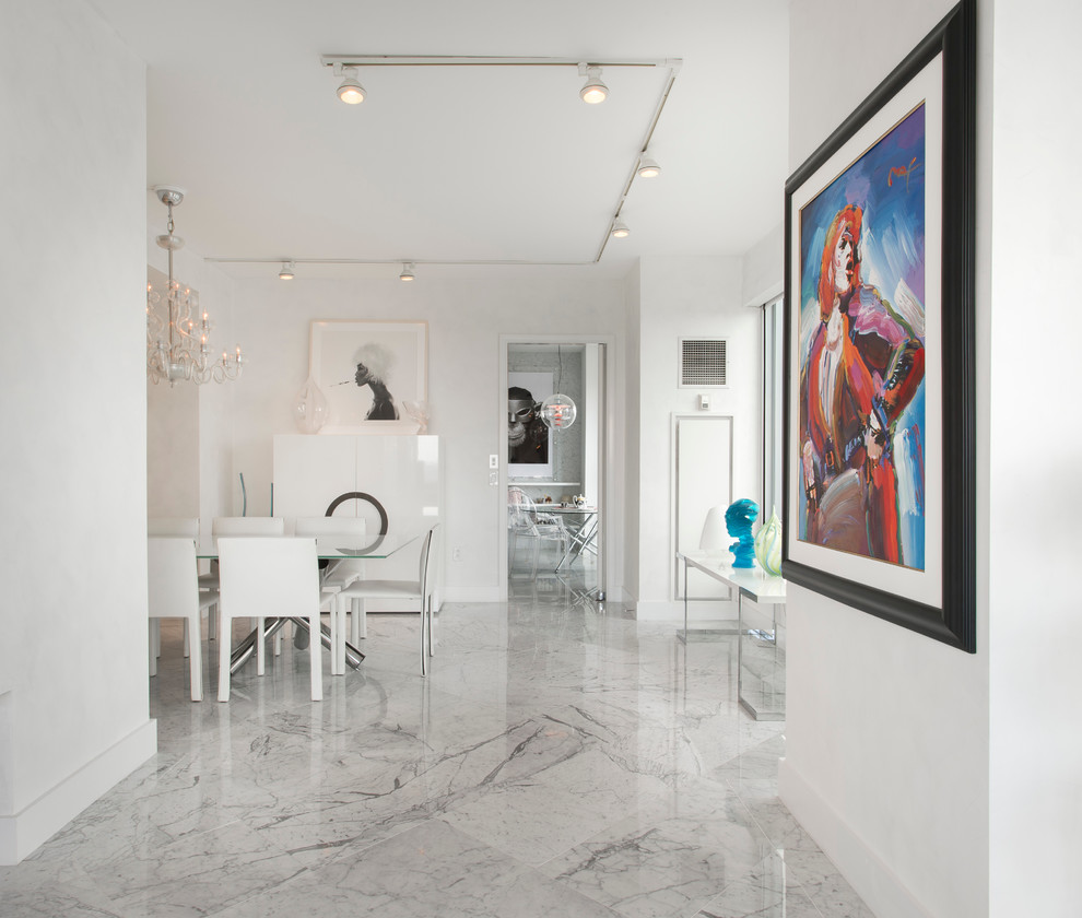 Cette image montre une grande salle à manger ouverte sur la cuisine design avec un mur blanc et un sol en marbre.