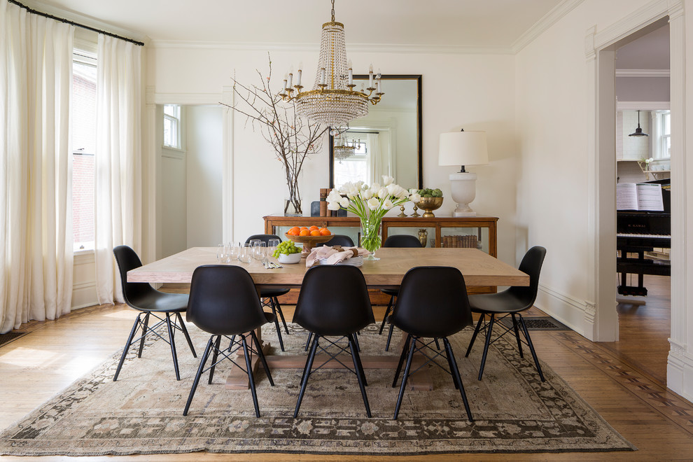 Example of an ornate medium tone wood floor enclosed dining room design in Chicago with white walls and no fireplace