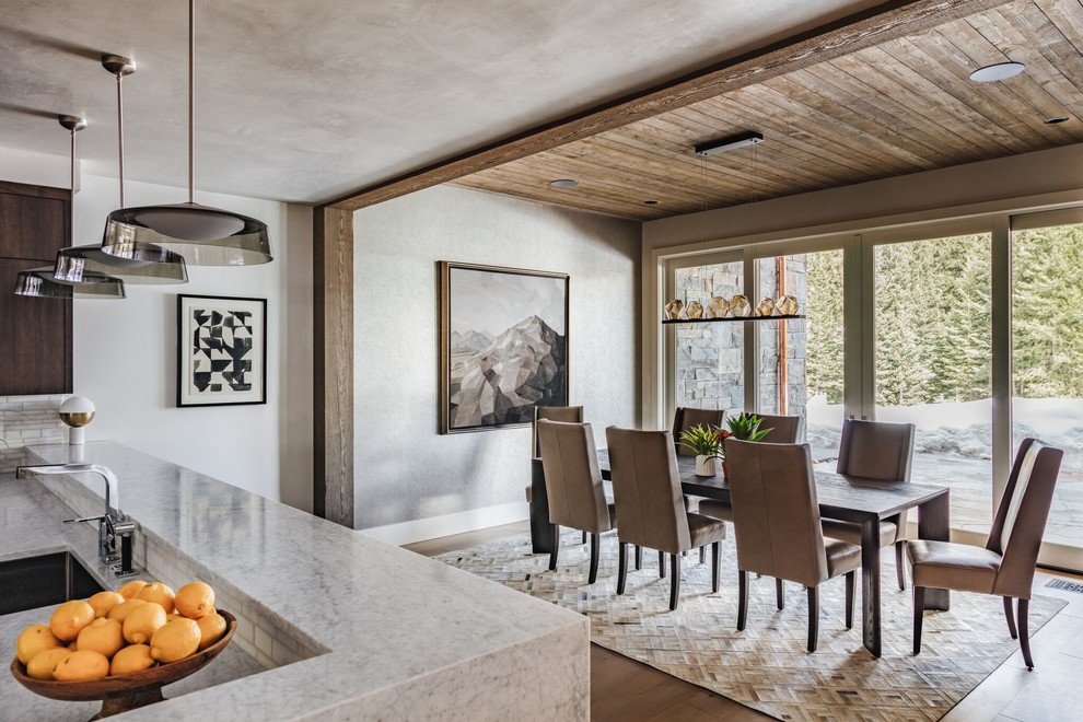 Example of a mountain style brown floor and medium tone wood floor dining room design in Los Angeles with gray walls