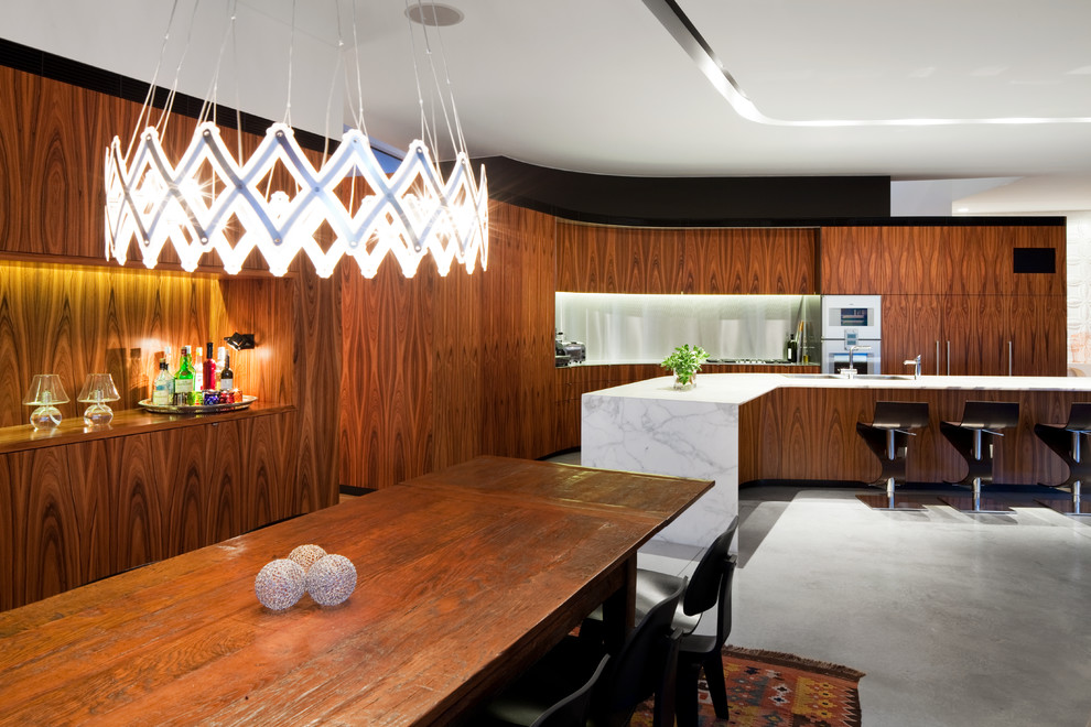 Idée de décoration pour une salle à manger design avec sol en béton ciré.