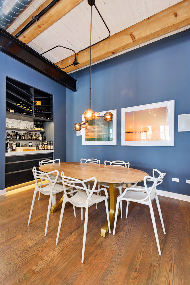 Exempel på en modern matplats med öppen planlösning, med blå väggar och mörkt trägolv