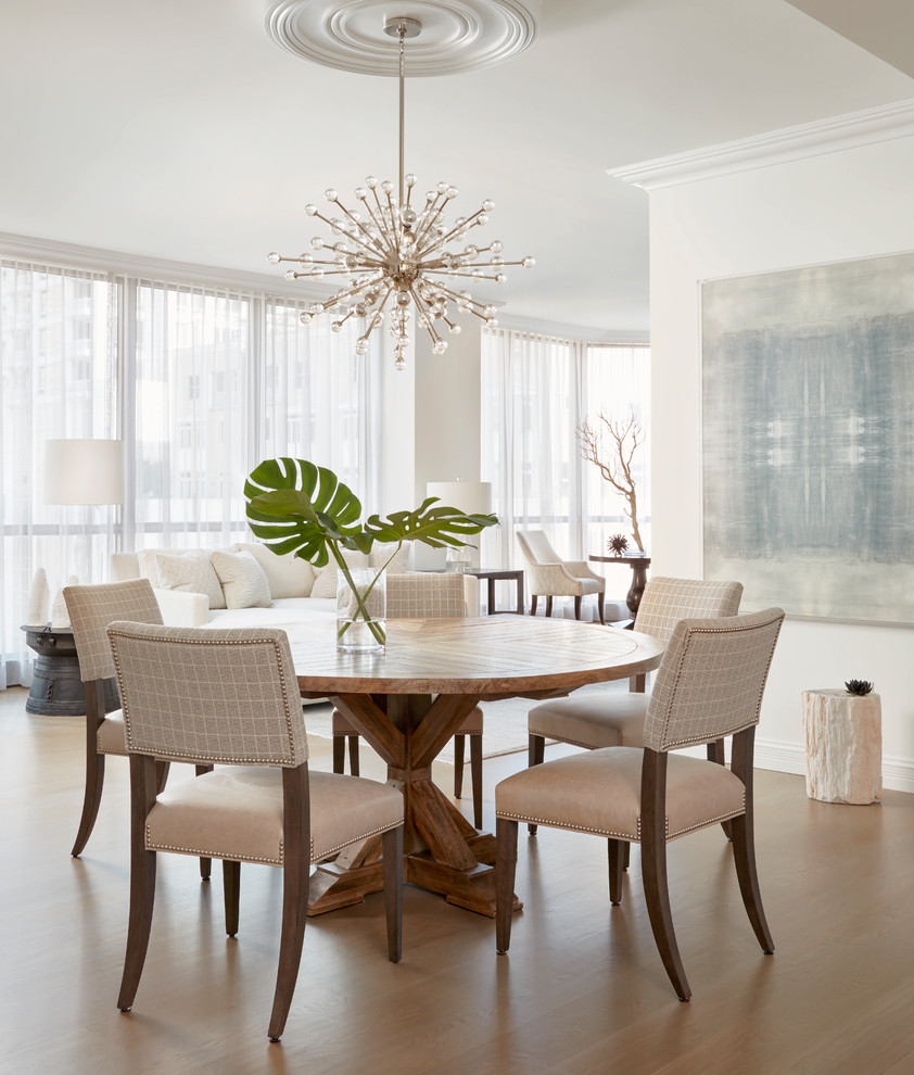 Photo of a coastal open plan dining room in Chicago with white walls, medium hardwood flooring, brown floors and feature lighting.