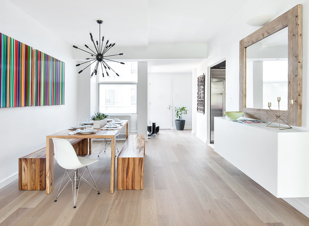 Immagine di una sala da pranzo minimal con pareti bianche e pavimento in legno massello medio