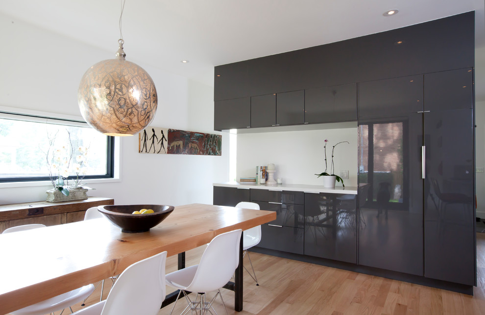 Mittelgroße Moderne Wohnküche ohne Kamin mit weißer Wandfarbe, braunem Holzboden und braunem Boden in Toronto