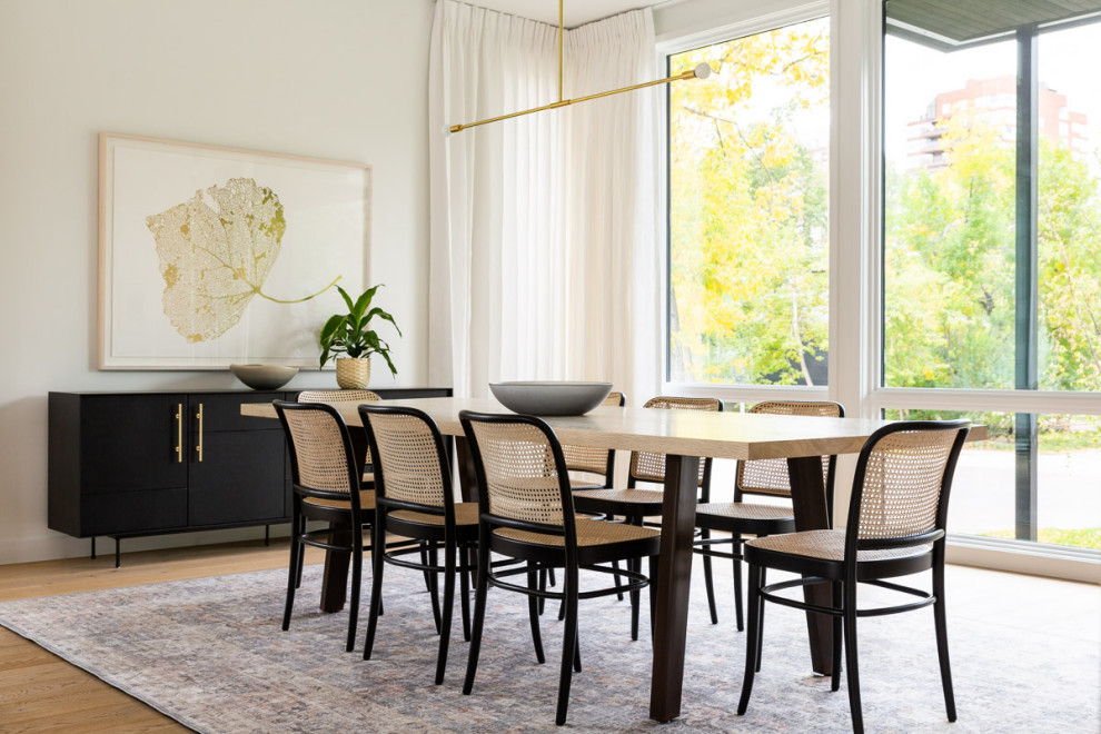 Immagine di una grande sala da pranzo aperta verso il soggiorno minimal con pareti bianche, parquet chiaro e pavimento beige
