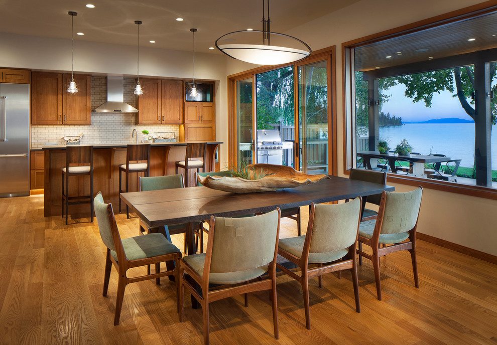 Idée de décoration pour une grande salle à manger ouverte sur la cuisine design avec un mur blanc et un sol en bois brun.