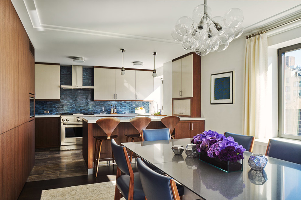 This is an example of a contemporary dining room in New York with white walls and dark hardwood flooring.