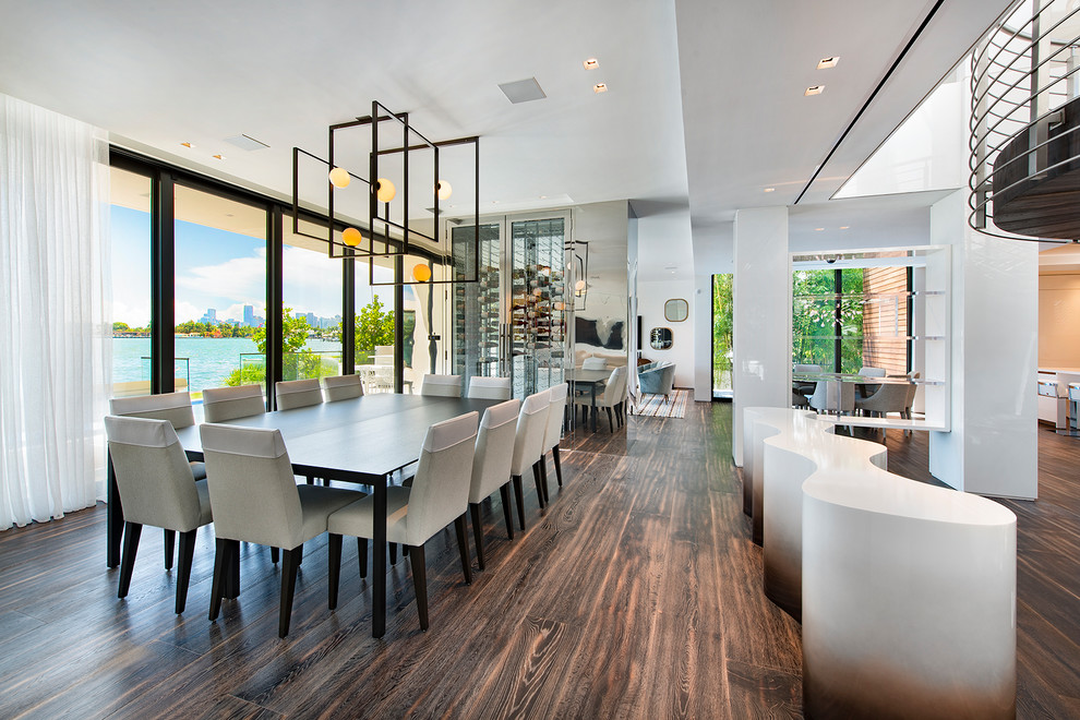 Offenes Modernes Esszimmer mit dunklem Holzboden und braunem Boden in Miami