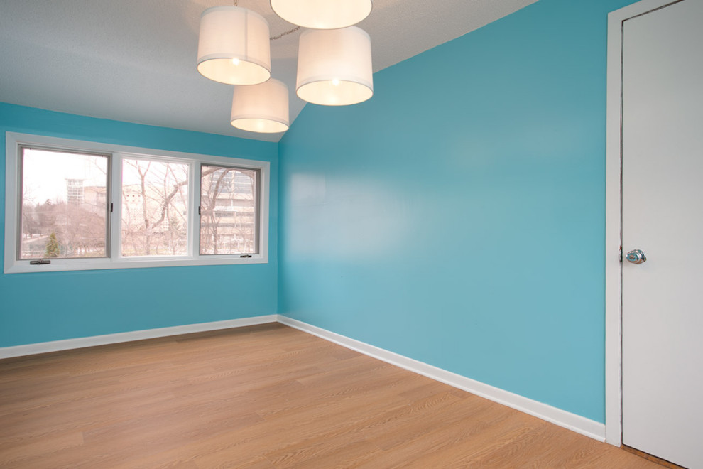 Geschlossenes, Mittelgroßes Mid-Century Esszimmer ohne Kamin mit blauer Wandfarbe, Laminat und braunem Boden in Minneapolis