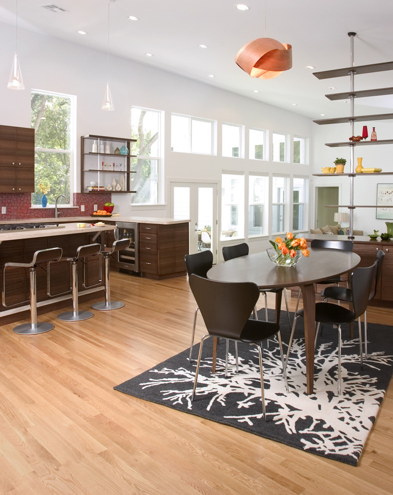 Contemporary open plan dining room in Austin with white walls and medium hardwood flooring.