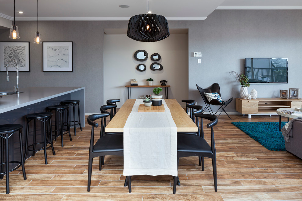 Réalisation d'une salle à manger ouverte sur le salon design avec un mur gris et parquet clair.