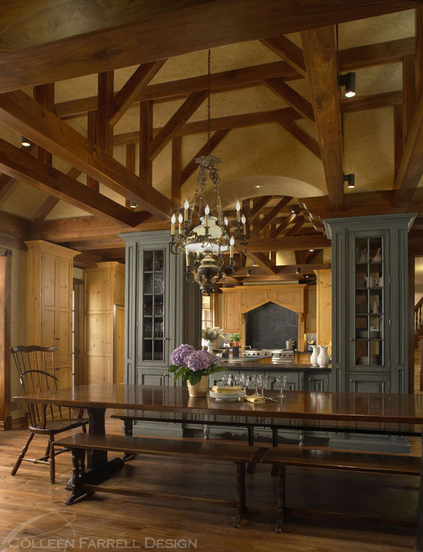 Example of a large classic dark wood floor kitchen/dining room combo design in Detroit with yellow walls, a two-sided fireplace and a stone fireplace