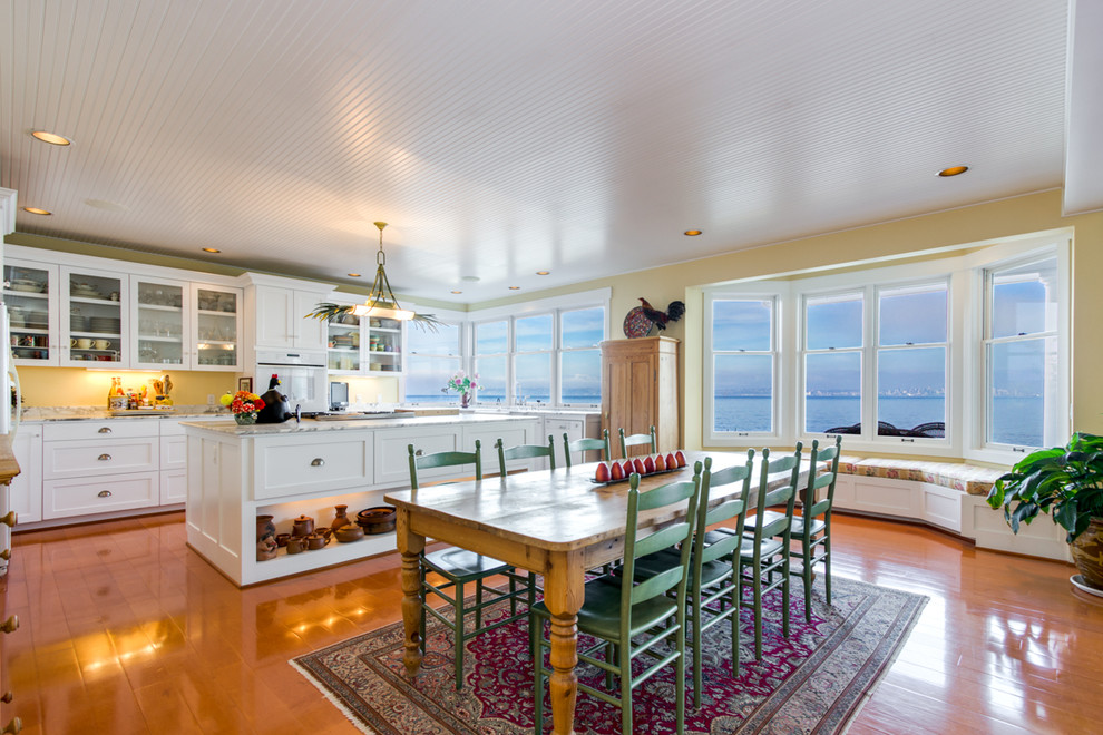 Mittelgroße Maritime Wohnküche mit gelber Wandfarbe und braunem Holzboden in Seattle