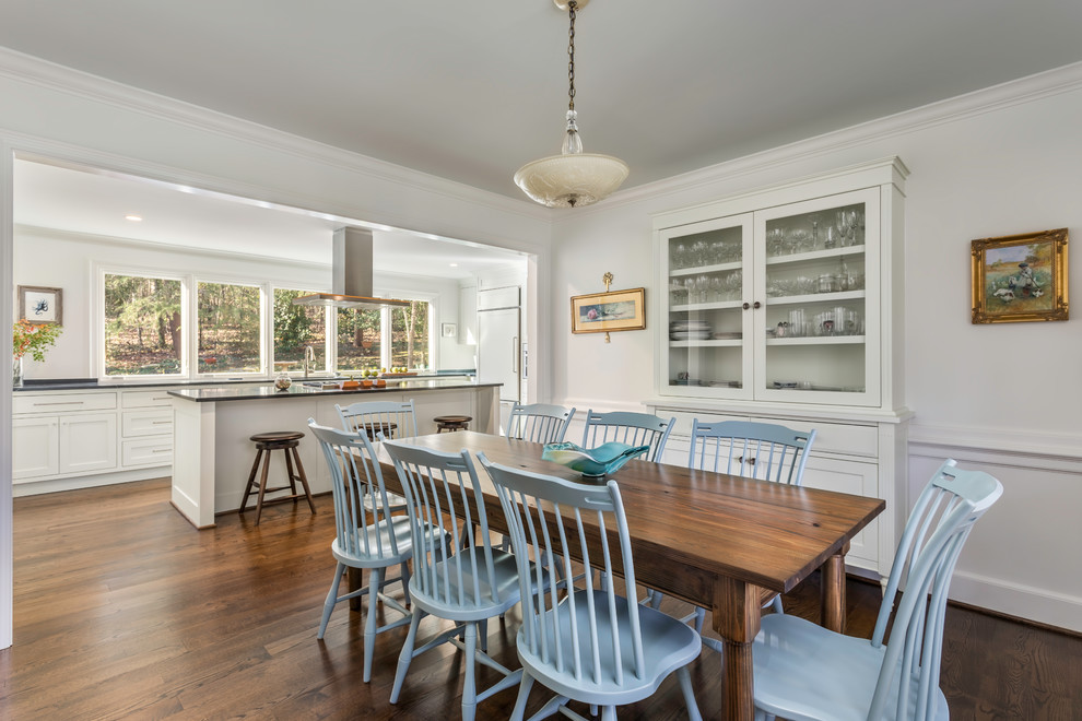 Esempio di una sala da pranzo aperta verso la cucina classica di medie dimensioni con pareti bianche, pavimento in legno massello medio e pavimento marrone