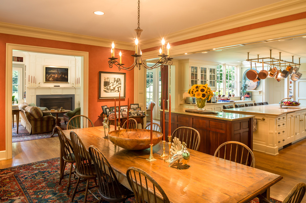 Klassische Wohnküche ohne Kamin mit braunem Holzboden und oranger Wandfarbe in Philadelphia