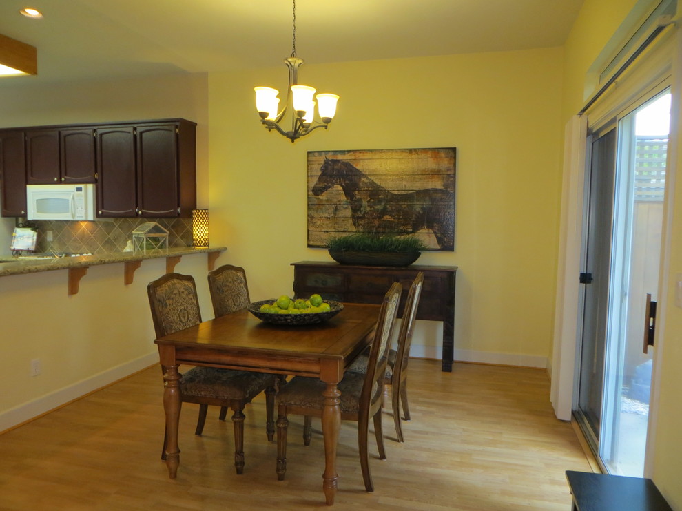 Idées déco pour une salle à manger ouverte sur la cuisine classique de taille moyenne avec un mur jaune, parquet clair, aucune cheminée et un sol beige.