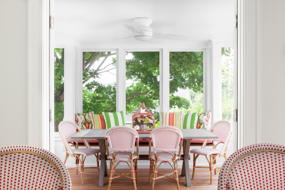 Enclosed dining room - coastal medium tone wood floor enclosed dining room idea in New York with white walls