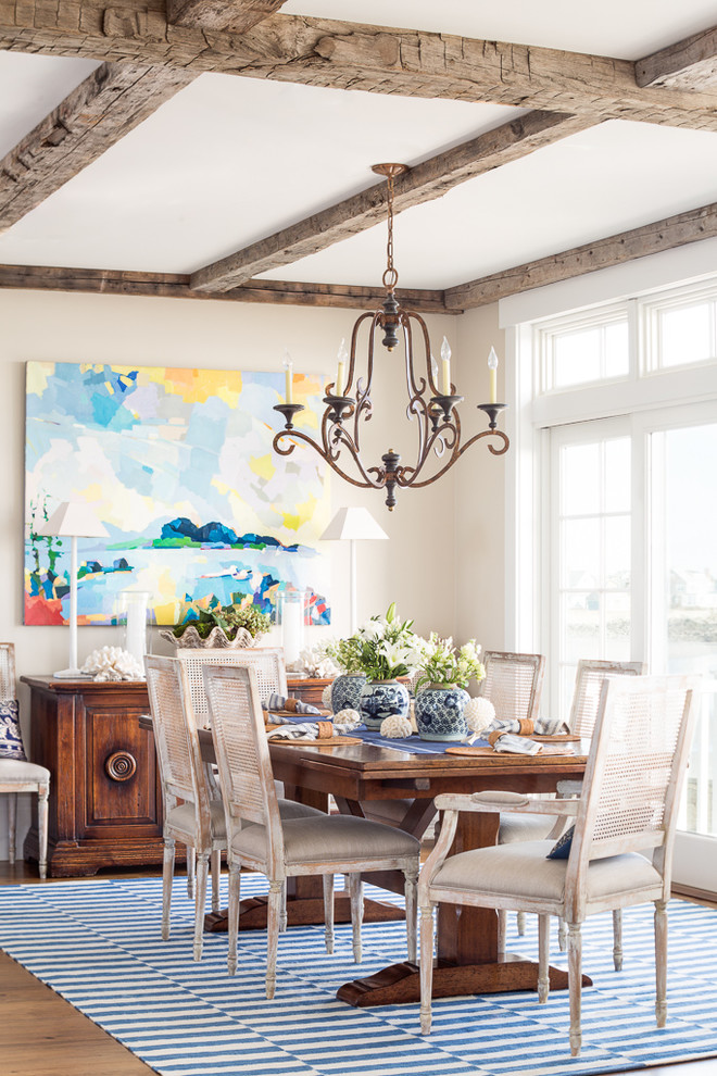 Immagine di una sala da pranzo costiera con pareti beige e pavimento in legno massello medio