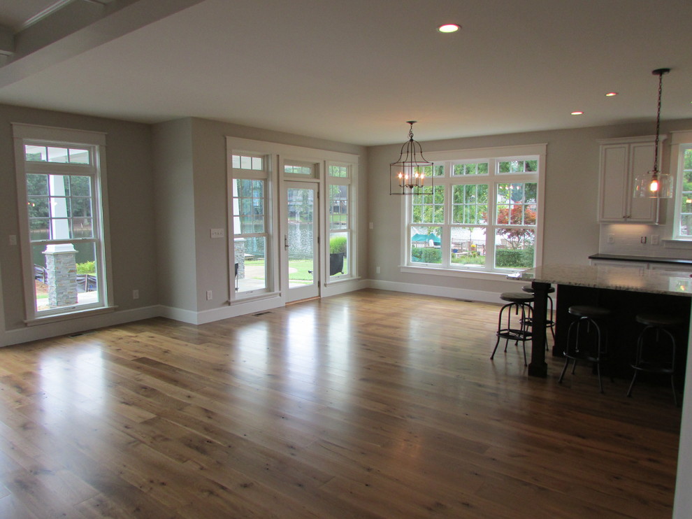 Immagine di una sala da pranzo aperta verso la cucina chic di medie dimensioni con pareti grigie e pavimento in legno massello medio