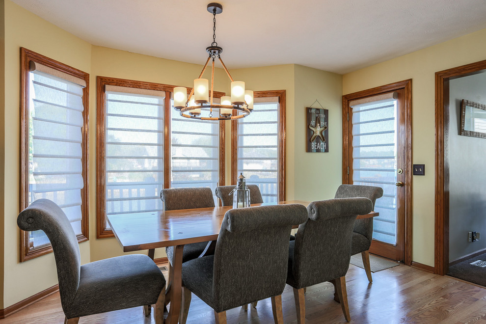 Example of a light wood floor kitchen/dining room combo design in Omaha with yellow walls