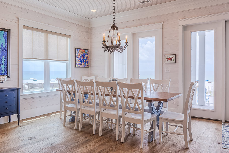 Ispirazione per una sala da pranzo aperta verso il soggiorno costiera di medie dimensioni con pareti beige, pavimento in legno massello medio e nessun camino