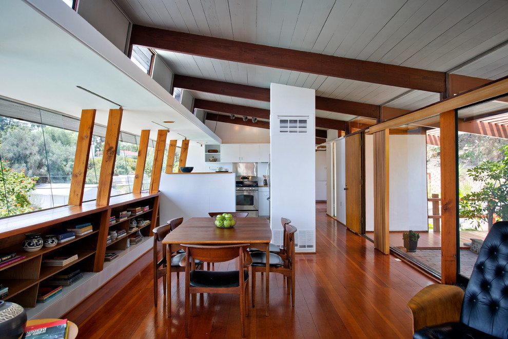 Idée de décoration pour une salle à manger ouverte sur le salon design avec un sol en bois brun.