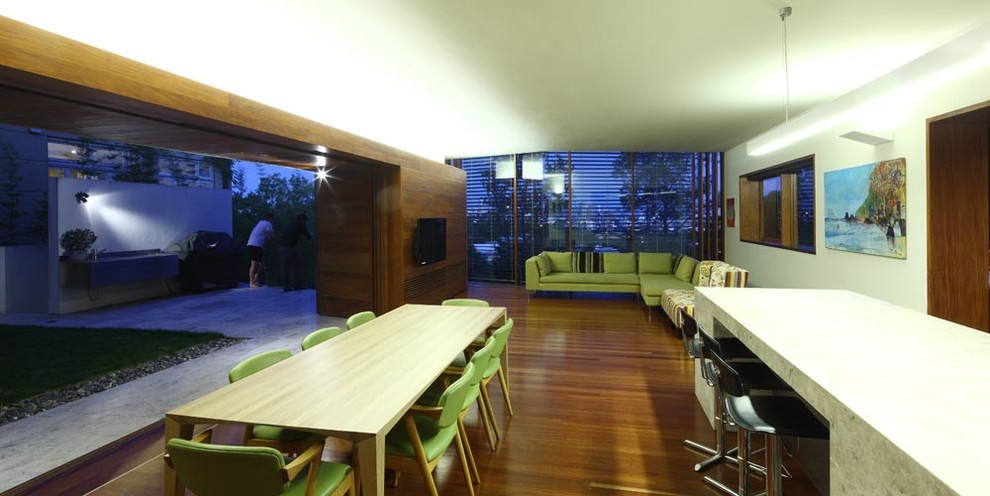 Idée de décoration pour une très grande salle à manger ouverte sur le salon design avec un mur blanc et un sol en bois brun.