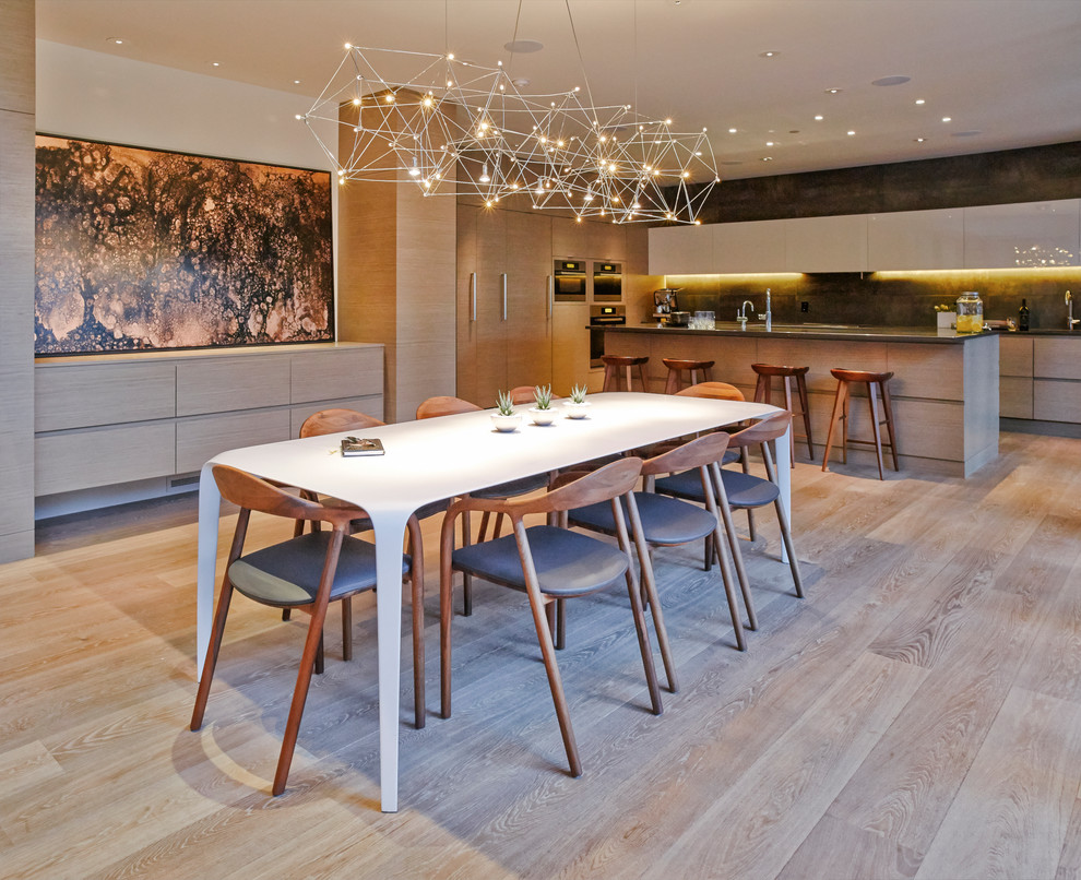 Aménagement d'une salle à manger ouverte sur la cuisine contemporaine avec parquet clair.