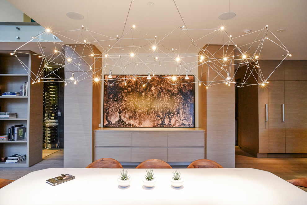 Immagine di una sala da pranzo aperta verso la cucina contemporanea con pareti bianche e parquet chiaro
