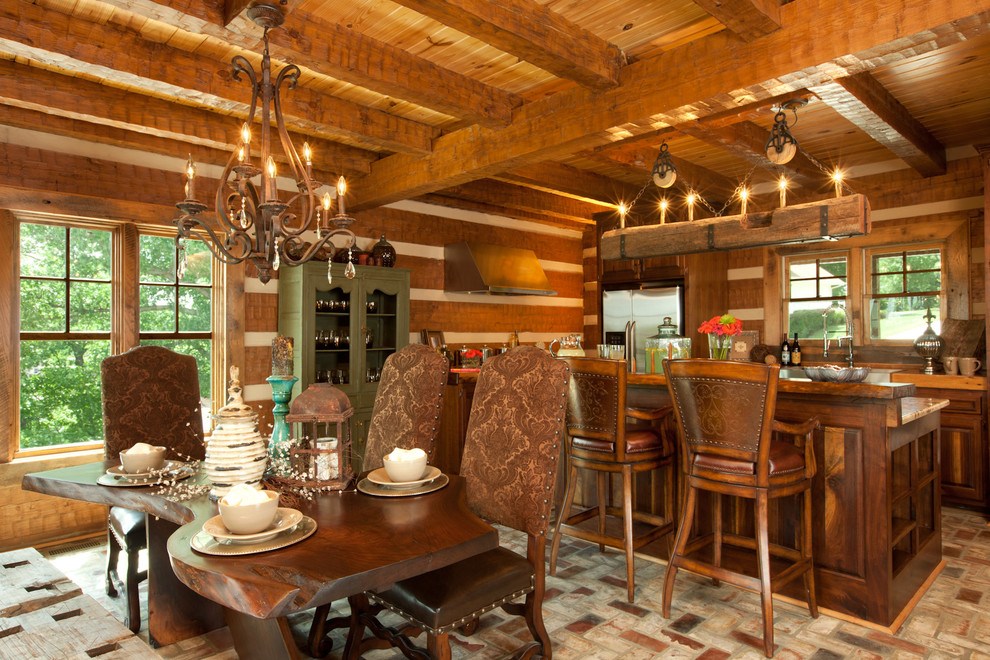 Esempio di una grande sala da pranzo aperta verso il soggiorno stile rurale con pareti marroni e pavimento in mattoni