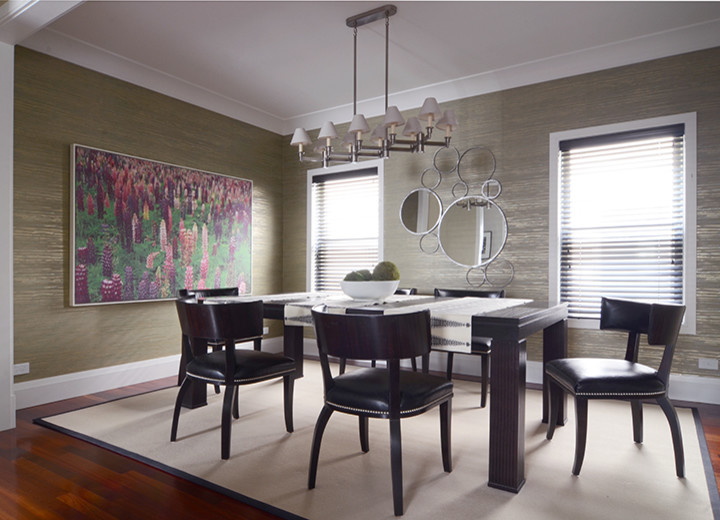 Cette image montre une grande salle à manger minimaliste fermée avec un mur vert, un sol en bois brun, aucune cheminée et un sol rouge.